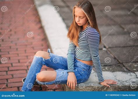 Young Teenage Poses For Photo Blonde Girl In Jeans And Blouse Stock