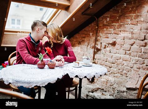 schöne stilvolle pärchen in einem roten kleid in liebesgeschichte im vintage café mit großen