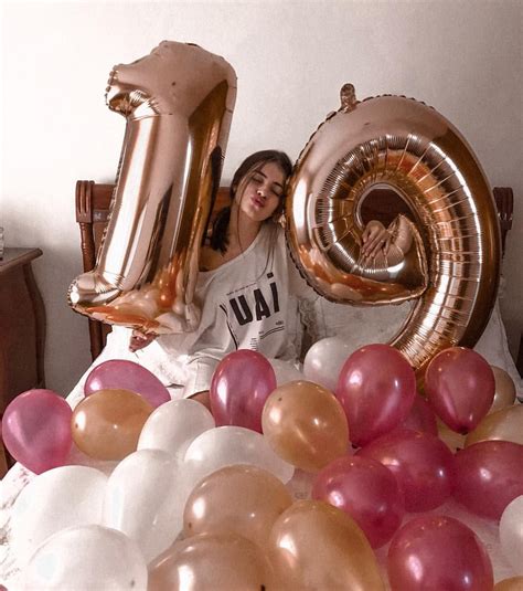 A Woman Sitting On A Bed With Balloons In Front Of Her And The Number Ten