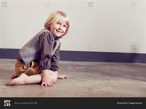 Mischievous Girl Kneeling On Floor Stock Photo Offset