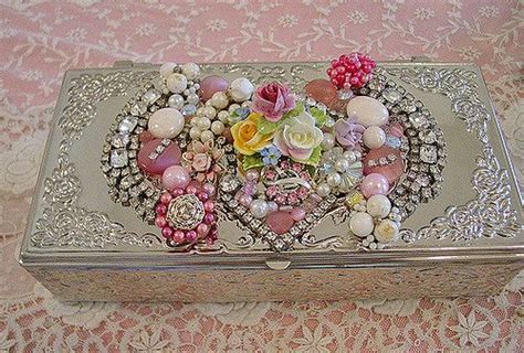 A Heart Shaped Box With Flowers And Pearls