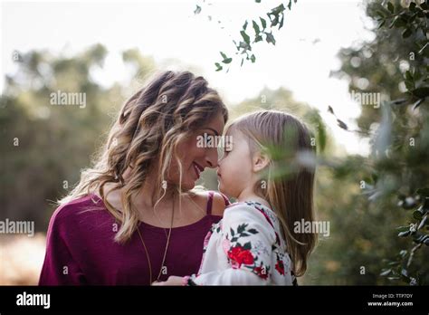 Loving Mother And Babe Rubbing Noses By Plants Stock Photo Alamy