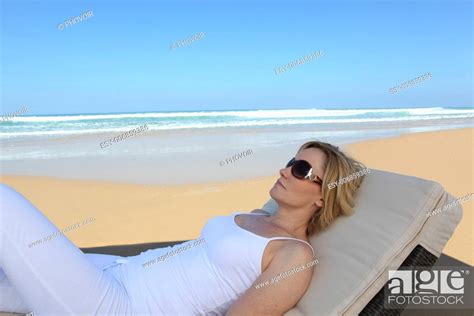 Woman Lying On A Lounge Chair At The Beach Stock Photo Picture And