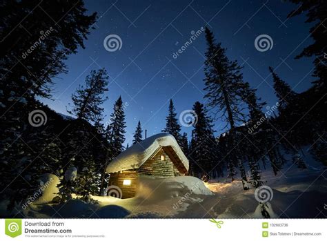Small Cottage In A Beautiful Snow Forest At Moon Night Stock Photo