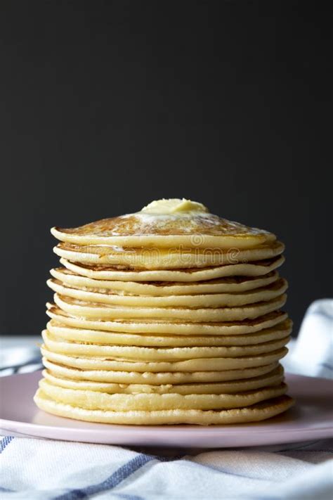 Stack Of Homemade Pancakes With Butter On Pink Plate Side View Stock