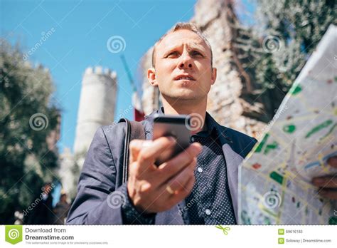 Tourist Man Try Navigate Himself With Map And Smartphone In Unknown