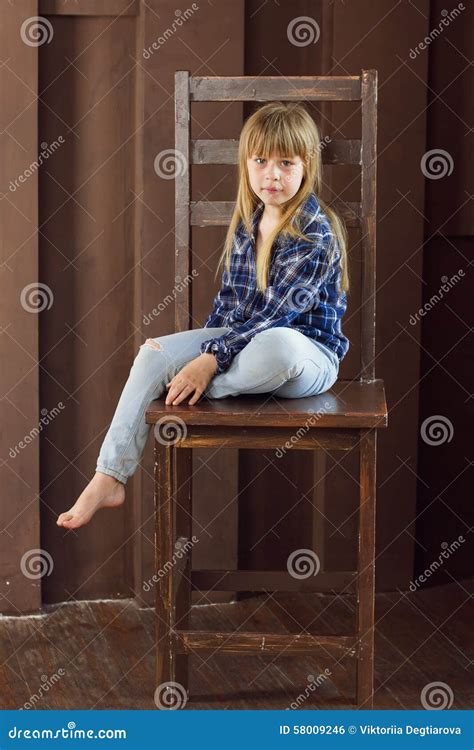 Het Meisje 6 Jaar Oude Jeans En Een Blauw Overhemd Zit Op Hoge Stoel In