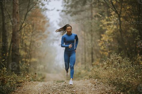 Young Woman Running Toward Camera On The Forest Trail At Autumn 5043886