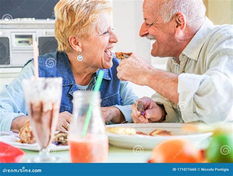 Happy Senior Couple Having Fun Eating Breakfast During Summer Travel