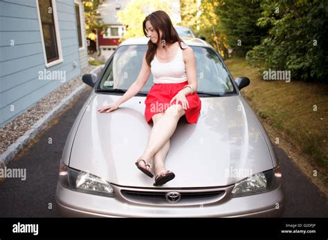 Woman Sitting On Car Hood Stock Photo Alamy