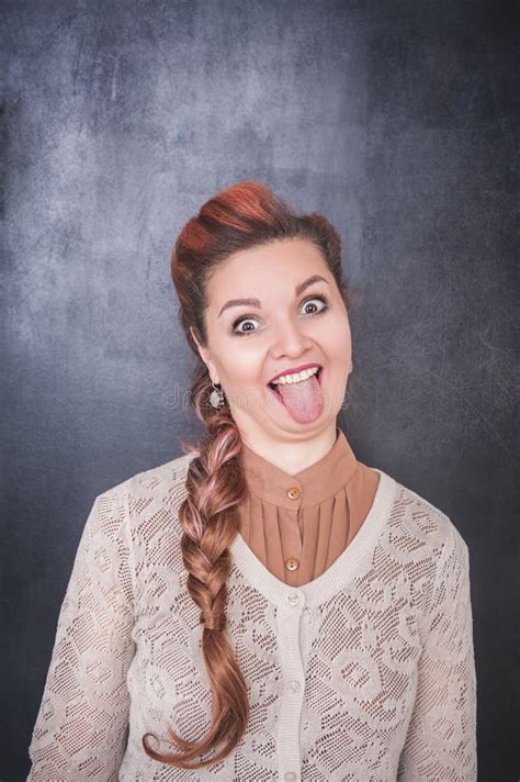 Beautiful Woman Showing Tongue On Chalkboard Background Stock Photo