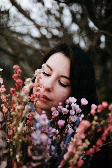 Portrait Of A Beautiful Woman Smelling The Flowers By Stocksy
