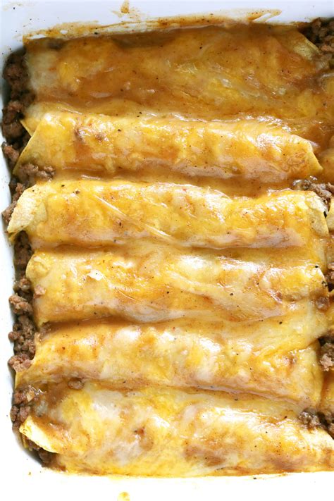This ground beef enchilada recipe is filled with grass fed ground beef, sautéed chopped yellow onions, pinto beans, enchilada sauce, freshly shredded cheddar cheese and topped off with sliced olives and chopped spring onions. authentic mexican ground beef enchiladas