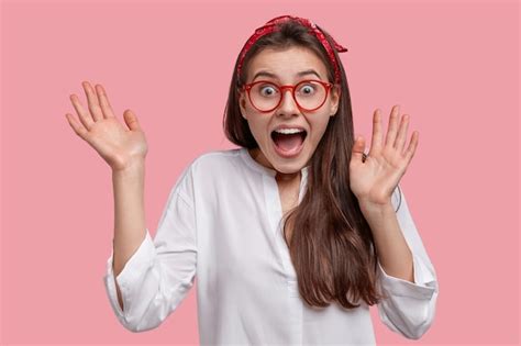 Free Photo Headshot Of Amazed Beautiful Woman Exclaims With Happiness Raises Hands Feels