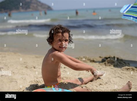 Smiling Girl Playing In The Sand On The Beach Thassos Greece Stock