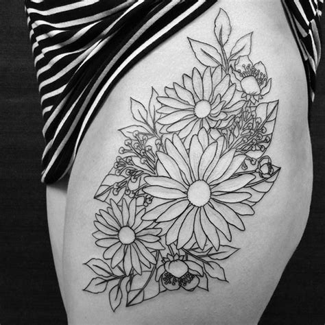 A Black And White Photo Of A Womans Thigh With Flowers On It