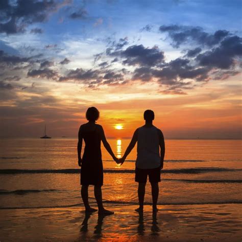Romantic Couple Holding Hands At Sunset On Beach Stock Photo By