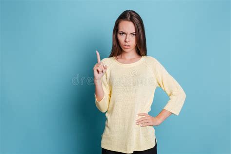 Serious Pretty Girl Pointing Finger Up And Looking At Camera Stock