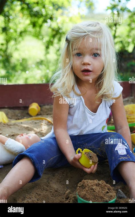 Little Blond Girl Playing In Sandpit At Summer Garden Stock Photo Alamy