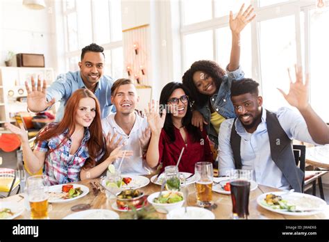 Happy Friends Eating At Restaurant Stock Photo Alamy