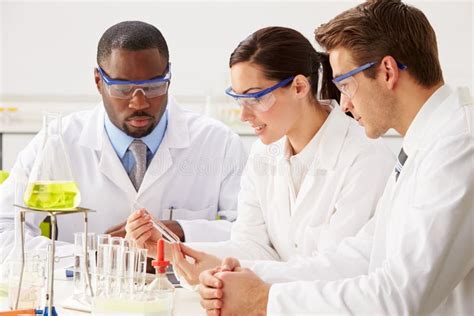 Group Of Scientists Performing Experiment In Laboratory Stock Photo