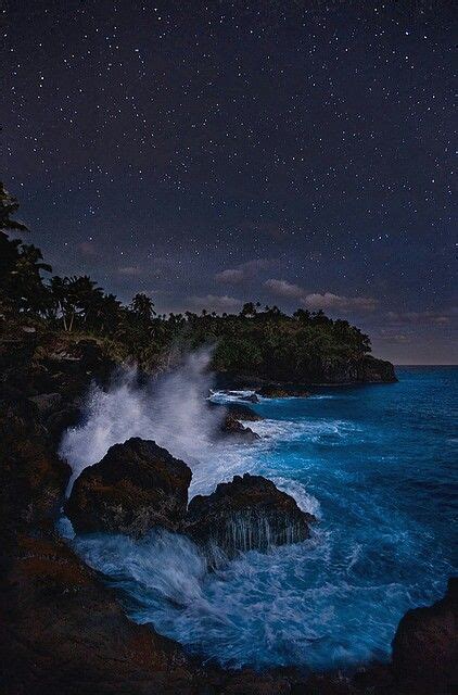The Night Sky Is Full Of Stars And Clouds Over The Ocean With Waves