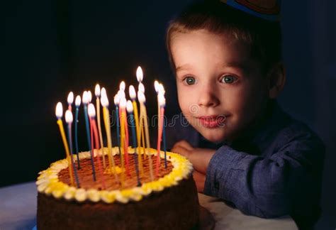 Birthday A Little Boy Blows Out Candles On The Stoke Stock Photo