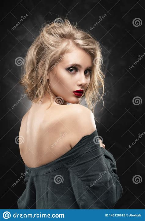 Beautiful Young Braless Slim Blonde Girl With Disheveled Hair And Aggressive Makeup Wearing An