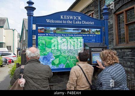 Foreign Tourists Examining A Map Of The Town Of Keswick Lake District Cumbria England Uk P4beah 