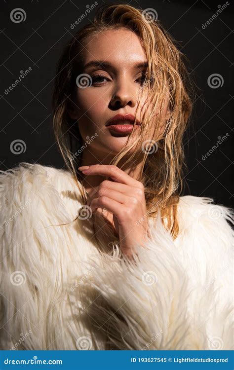 Young Woman With Wet Blonde Hair In White Faux Fur Coat Isolated On
