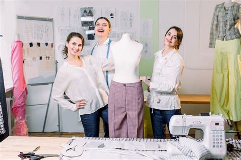 Tres Diseñadores De Moda O Sastres Sonriendo A La Cámara Y Midiendo