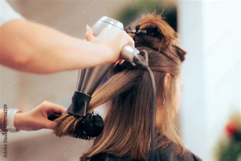 Woman Having Her Hair Straighten With A Brush And A Hair Dryer