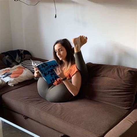 A Woman Sitting On Top Of A Brown Couch