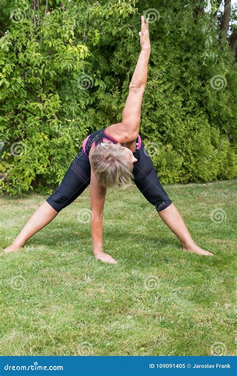Senior Blond Woman In Forward Bend Pose Stock Image Image Of Lawn