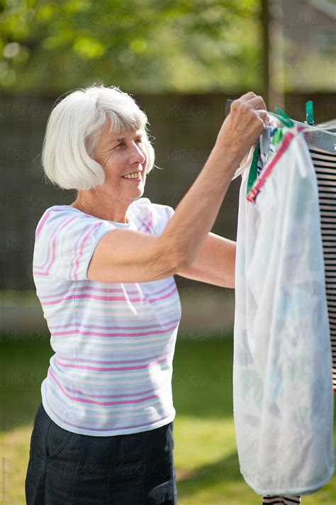 Senior Woman Hanging Out The Laundry Del Colaborador De Stocksy Lee
