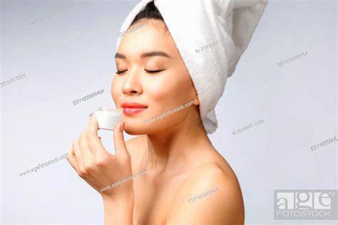 Health And Beauty Concept Attractive Asian Woman Applying Cream On Her Skin Isolated On White