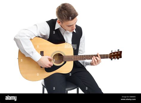 Young Man Playing On Acoustic Guitar Sitting On A Chair Isolated On