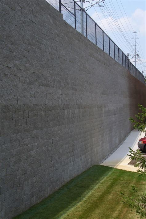 Concrete block retaining wall construction consists of number of phases including excavation, foundation soil preparation, retaining wall base construction, concrete block unit placement, grouting and drainage system installation. Rosch Company | Retaining Walls