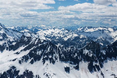 Majestic Scenery Of Snow Covered Mountain Range Under Sky With Clouds