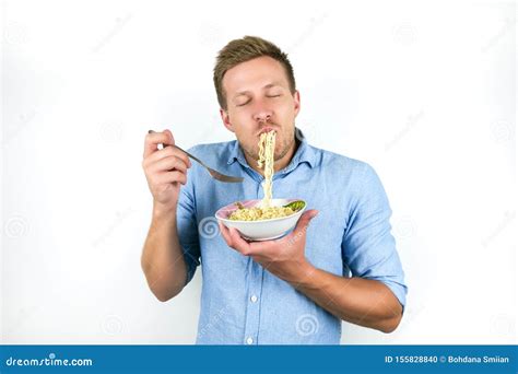 Young Handsome Man Eating Noodles Looks Hungry On Isolated White
