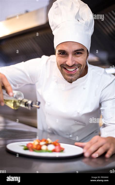Handsome Chef Pouring Olive Oil On Meal Stock Photo Alamy