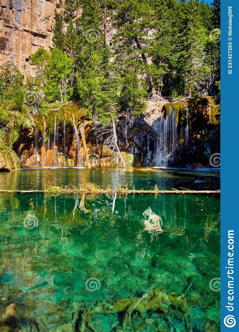Crystal Clear Teal Water Pond With Waterfalls Over Mossy Rocks Stock
