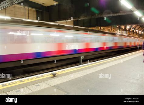 passengers waiting for tube train on london underground station platform hi res stock