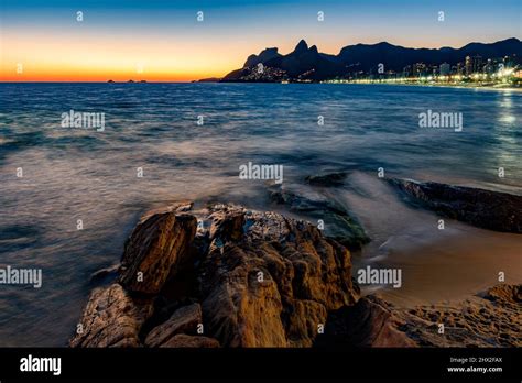 Sunset During The Summer With City Lights On At Ipanema Beach In Rio De