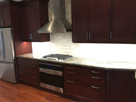 We absolutely love this open entrance kitchen concept, which is driven by the design and colour palette. Open concept kitchen with dark cabinets and quartzite ...