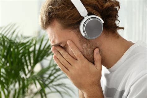 Sad Young Man Listening To Music On Color Background Stock Image