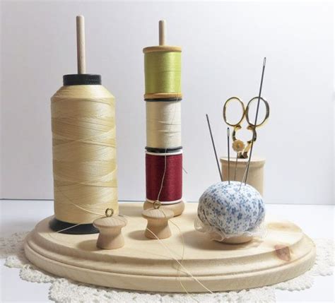 Three Spools Of Thread Sitting On Top Of A Wooden Stand