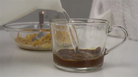 Young Woman Makes Instant Coffee With Milk Glass Goblet Close Up The Girl Prepares Breakfast