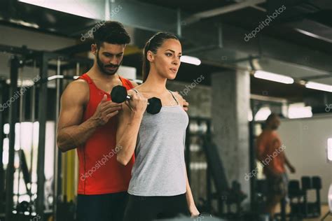 Personal Trainer Instructing Trainee In Gym 127062954 Larastock