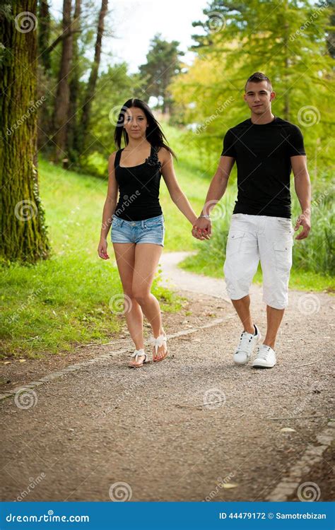 Teenage Couple Walking On A Late Summer Afternoon In Park Stock Photo
